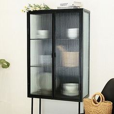 a black cabinet sitting next to a basket on top of a table