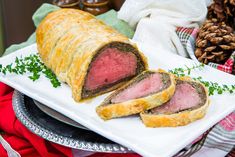 a meatloaf roll cut in half on a platter with pine cones and napkins