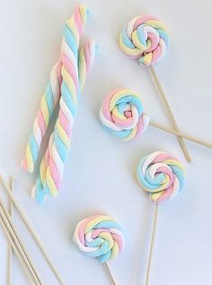 colorful lollipops and candy sticks on a white surface