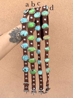 a person is holding several bracelets with turquoise and green beads