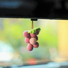 small crocheted fruit hanging from a window sill