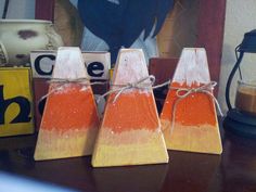 three orange and white wooden cones sitting on top of a table