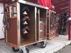 a horse trailer with many different types of saddles on it's back wheels