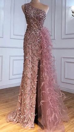 This blush gown is a showstopper, featuring a one-shoulder design that adds an asymmetrical and contemporary flair. It's adorned with exquisite sequin and beadwork that brings a touch of sparkle and luxury. The high slit ensures a dramatic, sultry look, while the feathered side drape adds a unique, whimsical element, enhancing the gown's elegance and sophistication. Perfect for making a memorable entrance at any formal occasion. Production time is between approx 6-8 weeks. * Sizing - All items a Blush Gown, Crystal Dress, Feather Tops, Sequin Beading, Shoulder Design, 8 Weeks, Dress Clothes For Women, Formal Occasion, Bead Work