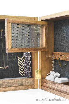 an open wooden box with jewelry and necklaces in it's display case on the wall