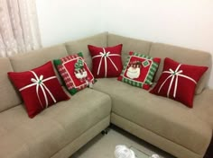 a couch with christmas pillows on it in front of a window