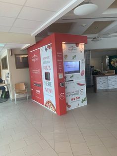 a vending machine sitting in the middle of a room next to a table and chairs