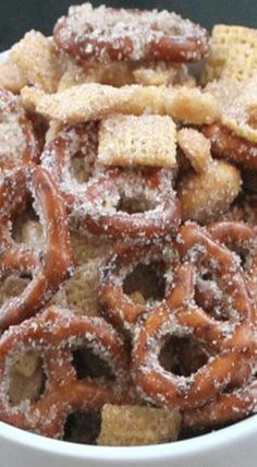 a white bowl filled with lots of pretzels and crackers on top of it