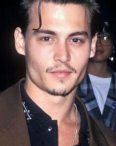 a close up of a person wearing a suit and tie with glasses on his head