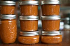 six jars of peanut butter sitting on top of a wooden table