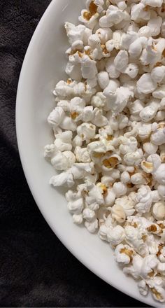 a white bowl filled with popcorn on top of a table