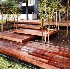 wooden steps leading up to a building with trees in the background and grass on the ground