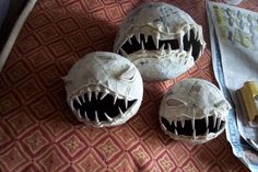 three fake monster heads sitting on top of a table