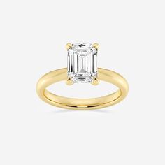 a yellow gold ring with an emerald cut diamond