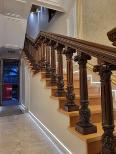 a staircase with wooden handrails and marble flooring