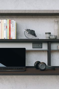 a laptop computer sitting on top of a wooden shelf next to a bookshelf