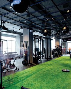 an indoor gym with artificial turf and exercise equipment