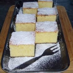 several pieces of cake on a tray with powdered sugar