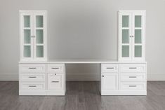 a white desk with two glass doors and drawers on the top, in front of a gray wall