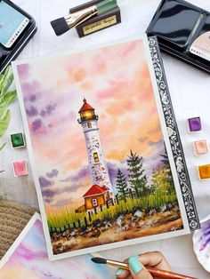 someone is painting a lighthouse with watercolors