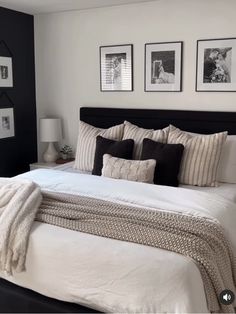 a large bed sitting in a bedroom next to two pictures on the wall above it