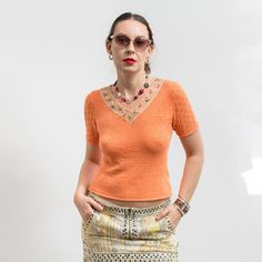 Vintage short sleeve top in orange - made of stretchy knitted fabric - openwork sleeves - neckline embellished with lace and beads - material: 50% cotton, 30% elastane, 20% viscose SIZE from the tag: no tag  Best fits women: M MEASUREMENTS (The blouse is made of stretchy material. The measurements were taken while the garment was lying flat) bust: 33 inches (84 cm) length: 21 inches (53 cm) The model is 5'9" (174 cm), measures 35-27-38 (90-69-96 cm) and typically wears clothing in size M CONDITI Orange V-neck Knit Top, Elegant Fitted V-neck Crochet Top, Fitted Lace Top T-shirt For Spring, Fitted Pointelle Knit Short Sleeve Top, Fitted V-neck Crochet Top With Pointelle Knit, Summer Cotton Pointelle Knit T-shirt, Orange Knit V-neck Top, Stretch Pointelle Knit Short Sleeve Top, Orange Stretch V-neck Top