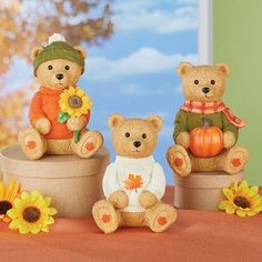 three teddy bears sitting on top of each other with sunflowers in front of them