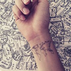 a person's wrist with a world map tattoo on the left side of their arm