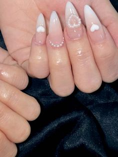 a woman's hands with white and clear nail polish on them, both holding their fingers together