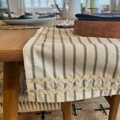 a close up of a table cloth on a wooden table with plates and utensils in the background