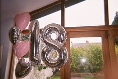 the balloons are shaped like the number eight and have been placed in front of an open window