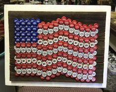 an american flag made out of beer bottle caps is displayed on a wooden frame in a shop