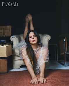 a woman laying on the floor in front of a chair with her legs spread out