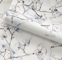 a white wallpaper with blue and gray flowers on it's side, next to a large sheet of paper