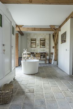 a large white bath tub sitting inside of a bathroom next to a wooden ceilinging