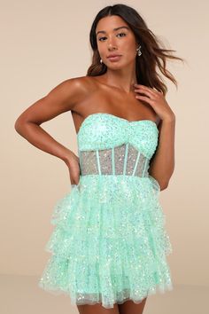 The Lulus Illustrious Glow Mint Green Sheer Tulle Sequin Tiered Mini Dress is perfect for any occasion that calls for extra extravagance! This sensational dress features a sparkling sequin design across the tulle-mesh construction that shapes a strapless, bustier-inspired bodice with sheer mesh paneling (along with supportive boning), a gathered bust with padded cups, and a sweetheart neckline with hidden no-slip strips. The high, fitted waist sits atop a fun and frilly tiered skirt that finishe Rapunzel Wedding Theme, Rapunzel Wedding, Sheer Clothing, Tier Dress, Strapless Bustier, Tiered Mini Dress, Tiered Ruffle Dress, Sequin Design, Sparkly Dress