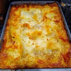 a square pizza sitting on top of a metal pan covered in cheese and toppings