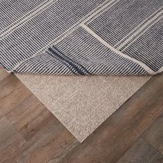 an area rug with wood flooring and blue plaid pattern on it, in the middle of