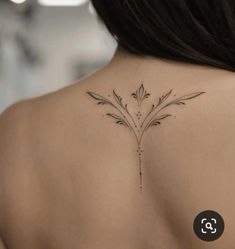 the back of a woman's shoulder with flowers on her left and an arrow tattoo