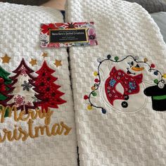 two white towels with christmas decorations on them