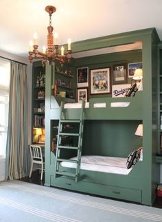 a green bunk bed in a room with a chandelier hanging from the ceiling