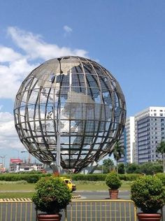 a large metal ball sitting in the middle of a park