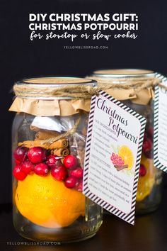 two mason jars filled with oranges, cranberries and christmas recipe tags sitting on top of a table