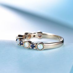 You are looking at a white fire Opal and sapphire wedding band. Stackable wedding band,matching band.A perfect anniversary gift, birthday gift,wedding engagement ring.Great as a gift for her. Ring Information Stones * 2.5mm Lab-treated opal +2mm lab created sapphire Metal * Solid 10k 14k &18k. *Color:white gold,yellow gold,rose gold. Custom Order *The main stone can be other gemstones you can imagine,any birthstone can be made.Please contact me if you need this service. *Any size *I can also Sapphire Stackable Birthstone Ring For Wedding, Multi-stone Sapphire Birthstone Ring For Wedding, Sapphire Stackable 14k Gold Rings For Wedding, Sapphire Stackable Rings In 14k Gold For Wedding, Sapphire Stackable Wedding Rings In 14k Gold, Stackable Sapphire Birthstone Ring For Wedding, Stackable 14k Gold Rings For Wedding, Round Half Eternity Sapphire Promise Ring, Elegant Round Half Eternity Sapphire Ring For Promise