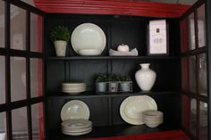 a china cabinet with plates and vases on it