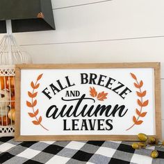 a sign that says fall breeze and autumn leaves on it next to some pumpkins