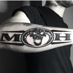 a black and white photo of a man's arm with the word mom tattooed on it