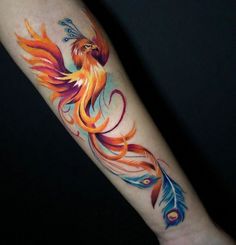 a colorful tattoo on the arm of a woman's arm with a bird and feathers