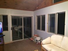 a living room with sliding glass doors and a television on the wall in front of it