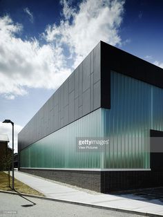 an empty building on the side of a road under a blue sky with white clouds